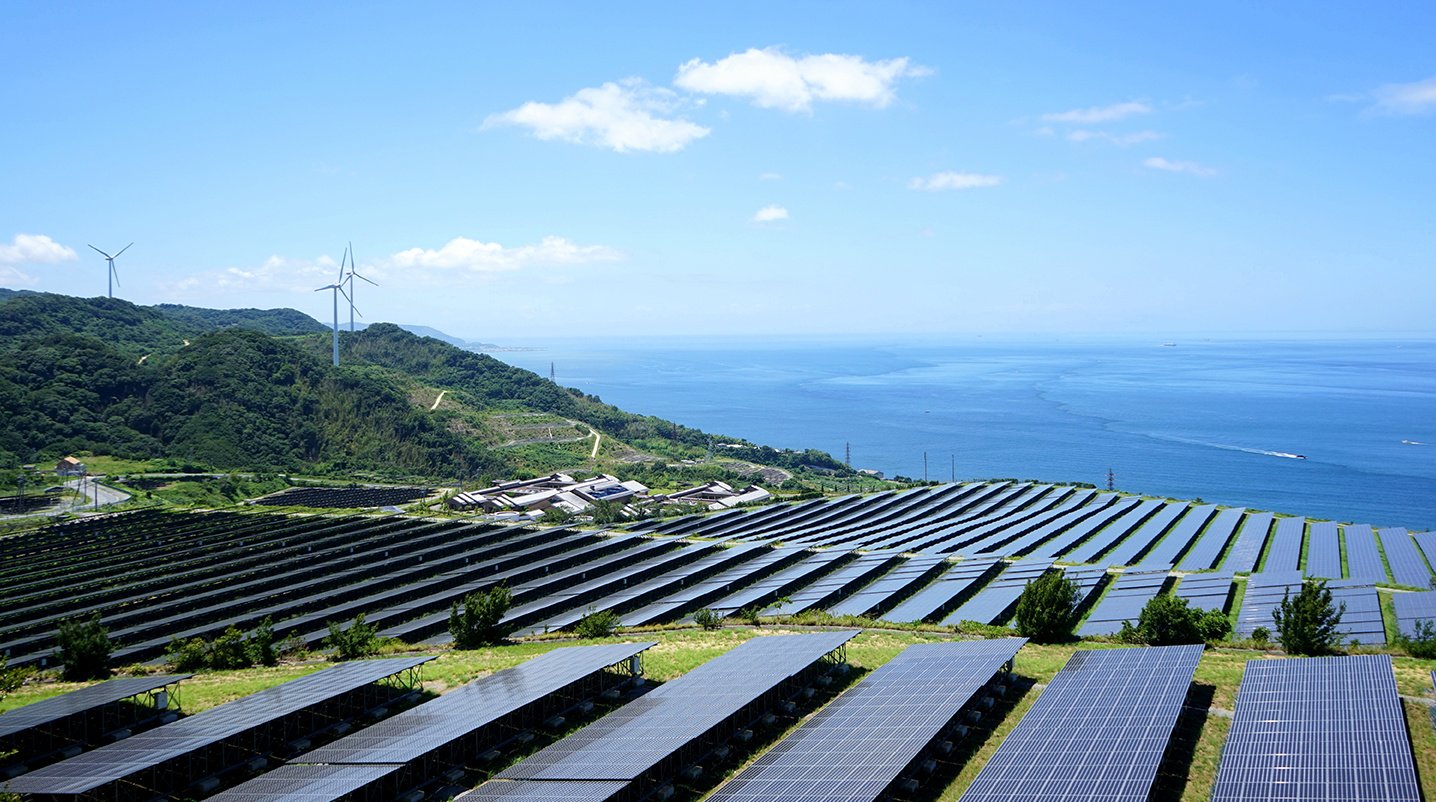 Solar panels and wind turbines next to the ocean